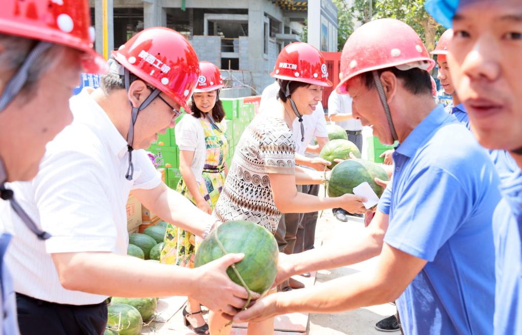 与会领导为建设工人送上慰问品